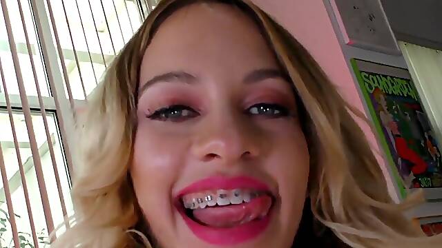 Blonde woman with braces is having fun with a big one
